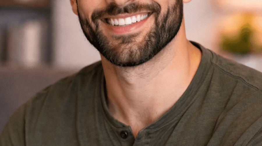 Ritratto di Matteo, un uomo sorridente con barba curata e capelli corti, che indossa una maglietta verde. Un'immagine ideale per un profilo professionale o personale.