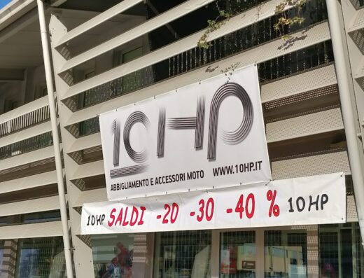 Foto del negozio 10HP SNC, abbigliamento e accessori moto, con cartelli saldi -20%, -30%, -40%. Vetrina con esposizione di prodotti per motociclisti.