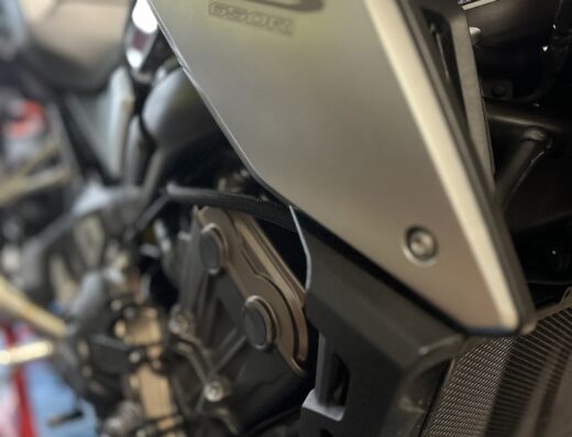 Dettaglio di una moto Honda CB 650R, con particolare attenzione al design del serbatoio e agli accessori di protezione del motore.