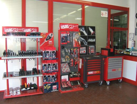 Esposizione di utensili USAG presso A.R.A.M. Sas di Damiano Damiani, con scaffali di cacciaviti, espositori di accessori e carrelli portautensili, ideali per officina moto e riparazioni.