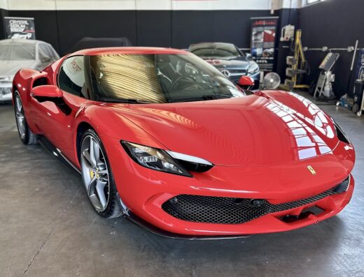 Auto sportiva rossa Ferrari 296 GTB presso A&D Detailing, un centro specializzato nella cura e nel detailing auto di lusso.