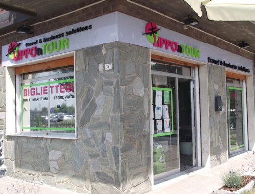 L'esterno dell'agenzia viaggi Lippontour travel & business solutions, con insegne e vetrine che pubblicizzano biglietti aerei, marittimi e ferroviari.