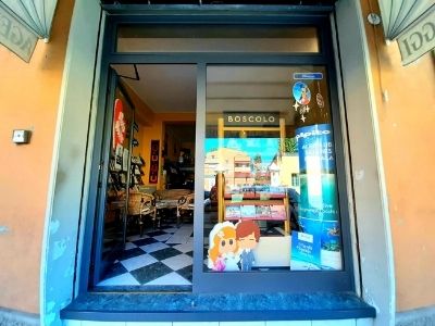 Vetrine dell'agenzia di viaggi Zenzero Viaggi, con porta d'ingresso in vetro che mostra l'interno con pavimento a scacchi.