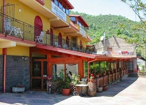 Agri Hotel da Marianna vista esterna, edificio giallo con balconi rossi e vista sulle montagne circostanti, atmosfera accogliente e rilassante.