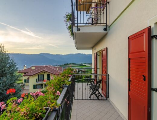 Agritur Cristina B&B: Vista panoramica dalla terrazza con fiori, balcone con sedie, montagne sullo sfondo, ideale per vacanze e relax in Trentino.
