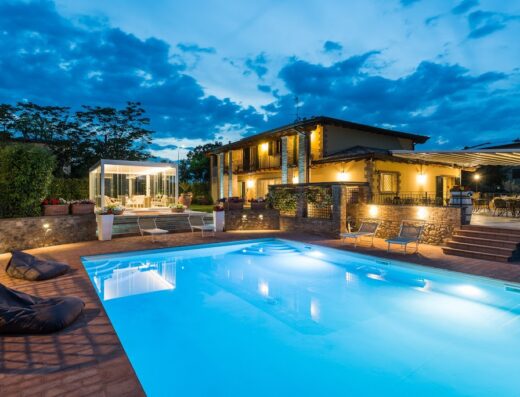 Agriturismo Acetaia Sereni vista piscina illuminata di sera, con gazebo e area relax, ideale per vacanze e soggiorni nel verde.