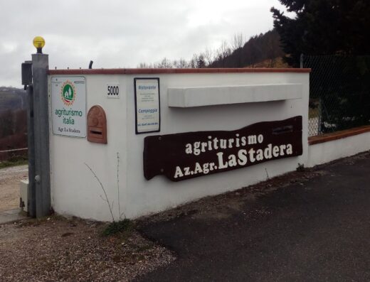Ingresso dell'Agriturismo Agricampeggio La Stadera, con cartelli indicativi di ristorante e campeggio, per vacanze in moto e relax.