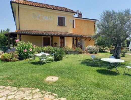 Agriturismo Ars Naturae, Italia: Veduta esterna della struttura con giardino curato, tavoli e sedie per gli ospiti, ideale per eventi e relax.