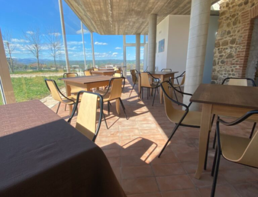 Ristorante all'aperto di Agriturismo Azienda Agricola B&B Arcadia con tavoli e sedie, vista panoramica sulla campagna toscana. Ideale per viaggi e vacanze.