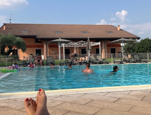 Agriturismo Ca' del Gal: People enjoying a swimming pool with lounge chairs and a building in the background under a sunny sky.