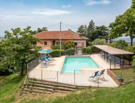 Agriturismo Cantine Bevione: Vista panoramica della piscina con ombrelloni e lettini, circondata dal verde della campagna italiana.