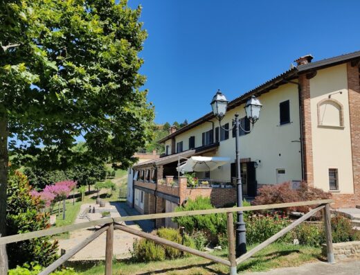 Agriturismo Carlincarlota: vista esterna della struttura con giardino curato, lampioni decorativi e architettura tradizionale italiana.