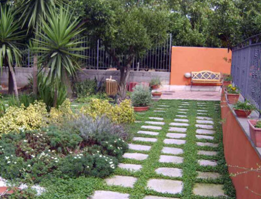 Agriturismo Villa Julia: pittoresca area camper con sentiero lastricato, vegetazione lussureggiante e panchina invitante per una sosta rilassante e una vacanza immersi nella natura