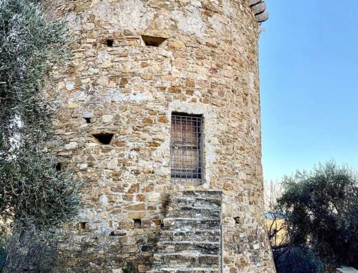 Torre in pietra con scala esterna all'Agriturismo Coppi Rossi, architettura storica in un contesto rurale suggestivo.