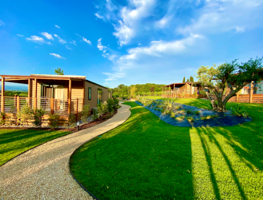 Agriturismo CorteZenati Lago di Garda: Chalet in legno con vialetto di ghiaia e prato verde, un'oasi di relax nel verde.