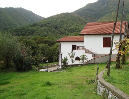 Agriturismo in Costiera Amalfitana: Veduta esterna di una casa colonica bianca con tetto rosso immersa nel verde delle montagne.
