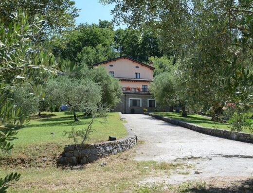 Agriturismo Fiore vista esterna: Casale in pietra con giardino di ulivi, ideale per un soggiorno rilassante e per motociclisti in cerca di avventura.