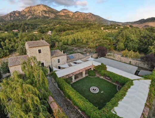 Agriturismo Giardino Donna Lavia a Polizzi Generosa, nel cuore del Parco delle Madonie. Vista aerea del ristorante con giardino curato e montagne sullo sfondo.