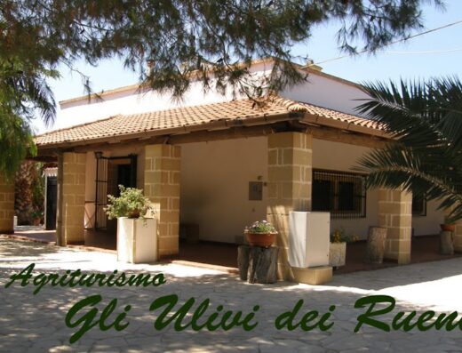 Agriturismo Gli Ulivi dei Rueni, una vista esterna della struttura con portico e piante, ideale per un soggiorno rilassante in campagna.