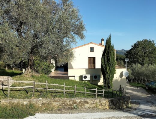 Agriturismo I Sapori del Parco, vista esterna della struttura con giardino curato e recinzione in legno, tipica architettura rurale italiana.