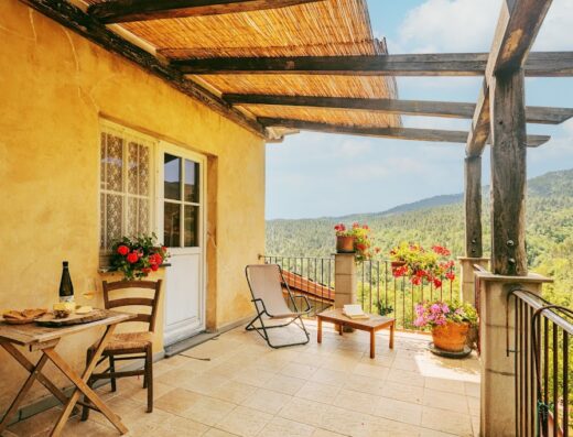 Balcony at Agriturismo Il Filo di Paglia with a table set for a meal, overlooking the Tuscan countryside. Relaxing travel experience in Italy.