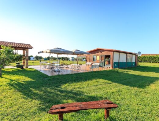 Agriturismo Il Gelsomino Ritrovato: Esterno con area ristoro, tavoli ombreggiati e prato verde, ideale per relax e viaggi in moto.