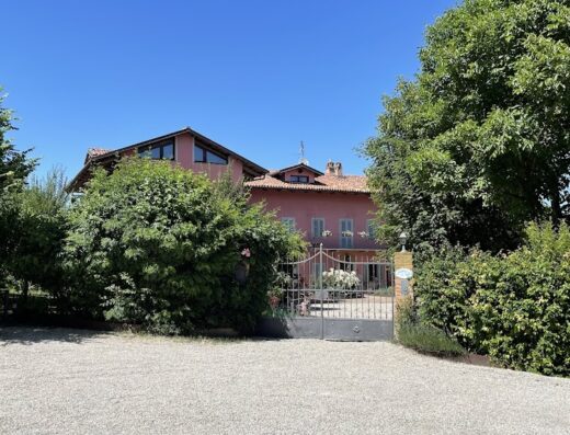 Agriturismo Il Gioco Dell'Oca: Esterno della struttura con cancello in ferro battuto, vegetazione rigogliosa e cielo azzurro.