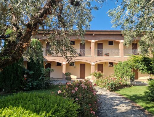 Agriturismo Il Quadrifoglio: facciata esterna con balconi, archi in mattoni, giardino curato e vialetto in pietra.