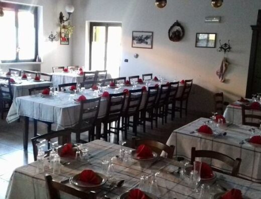 Interno dell'Agriturismo La Canestra con tavoli apparecchiati e pronti per gli ospiti, ambiente accogliente e tipico.