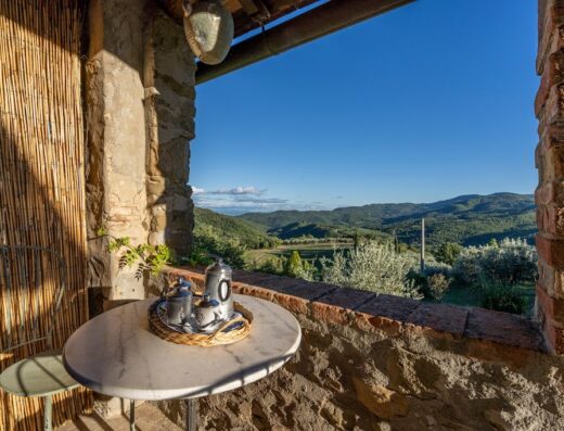 Scenic view from Agriturismo La Sala in Greve in Chianti, featuring a table with coffee service overlooking the rolling hills of Tuscany.
