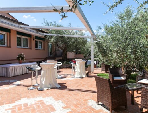 Agriturismo Locanda Antiche Macine: area esterna con tavoli e sedie in vimini, ideale per eventi e ricevimenti in un ambiente rilassante e immerso nel verde.