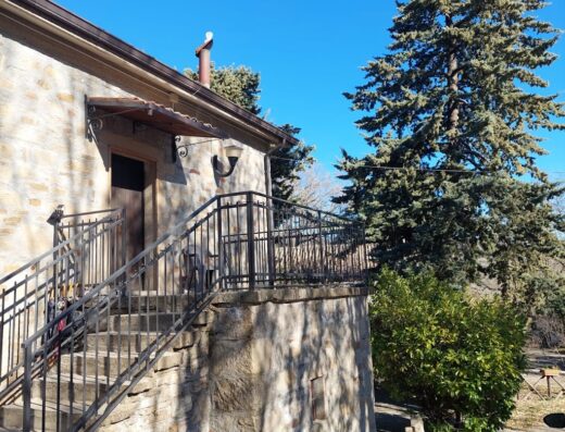 Agriturismo Madonna Del Saulo: Esterno in pietra con scala, cancello in ferro battuto e pino secolare, ideale per viaggiatori in moto.