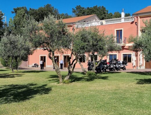 Agriturismo Mielita: Gruppo di motociclette adventure parcheggiate nel prato di fronte alla struttura. Persone in piedi vicino all'ingresso.