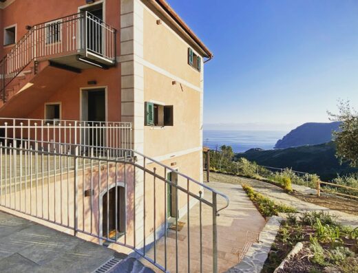 Agriturismo Missanega vista esterna, edificio color pesca con balconi in ferro battuto e vista panoramica sul mare e sulla costa ligure.