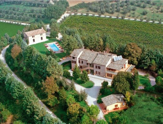 Vista aerea dell'Agriturismo Perugia Podere Caldaruccio La Pineta, con piscina, vigneto e architettura tipica umbra.