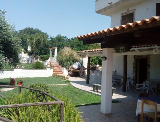 Agriturismo Pinturicchio: Esterno con carretto decorativo, tavoli apparecchiati sotto il portico e giardino curato.