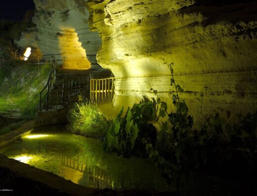 Agriturismo Rudì: Scenic view of illuminated rock formations and a reflective pool at night, creating a tranquil atmosphere.