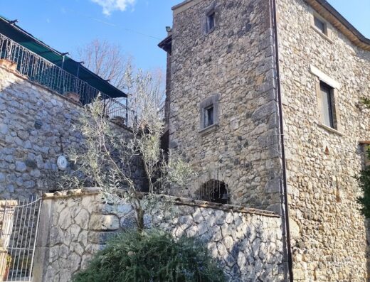 Agriturismo San Cristoforo: Exterior view of the stone building with a small tree in front, showcasing the rustic charm of this Italian travel destination.