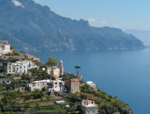 Veduta panoramica dell'Agriturismo Serafina affacciato sulla Costiera Amalfitana, con case colorate, terrazze e vista sul mare e sulle montagne.