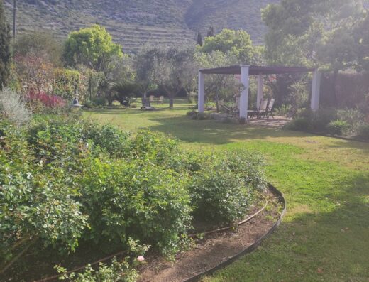 Agriturismo Villa Prato: Tranquillo giardino con vegetazione lussureggiante, gazebo bianco e vista sulle colline circostanti, ideale per un soggiorno rilassante.