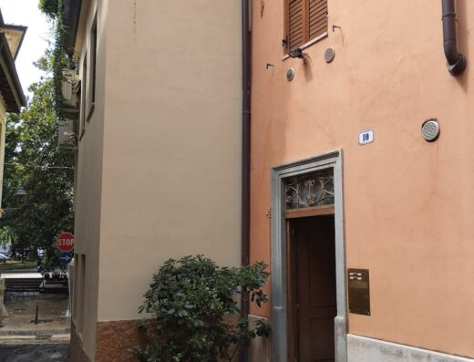 Al Vicoletto: Esterno di un edificio con porta d'ingresso e finestra con persiane in legno, situato in una strada stretta.