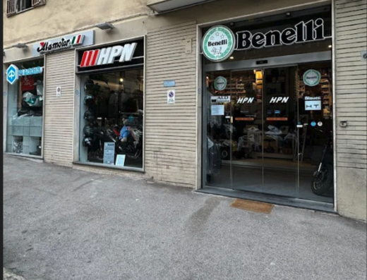 Negozio di moto ad ALAMOTOR HPN NAPOLI con concessionario Vespa, accessori moto e ricambi. Vetrina Benelli e caschi moto in esposizione.