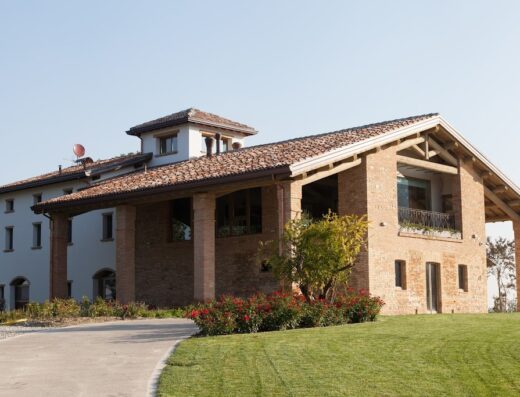 Alba del Borgo: Veduta esterna della struttura ricettiva con dettagli architettonici in mattoni e pietra, immersa nel verde.