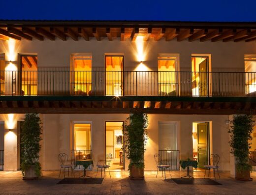 Albergo Al Moretto di Luciana Rigato: Facciata illuminata dell'hotel con balconi, tavolini esterni e dettagli architettonici accoglienti. Ideale per motociclisti in viaggio.