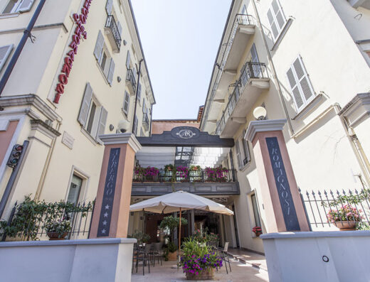 Albergo Casa Romagnosi, a charming hotel entrance with outdoor seating, flowers, and classic Italian architecture, ideal for travelers.