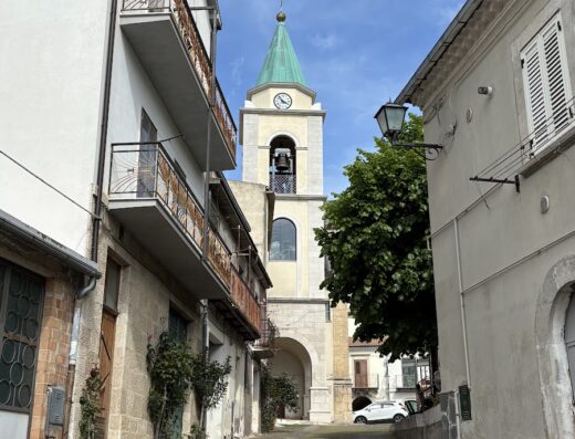 Albergo Diffuso Borgo delle Fonti: Scorcio pittoresco di una via acciottolata con vista sulla torre campanaria di una chiesa, tipico esempio di architettura italiana.