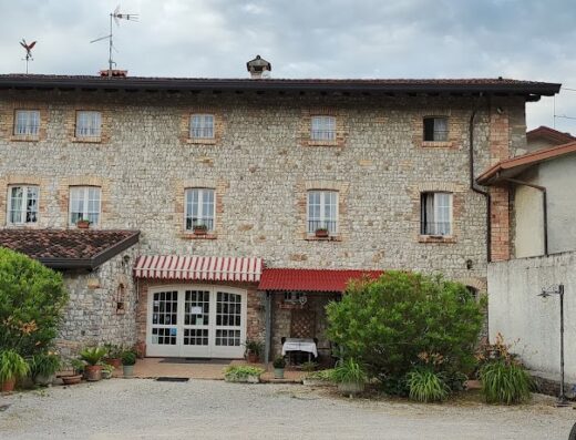 Albergo Julienne: Facciata in pietra dell'hotel con moto BMW GS parcheggiata, ideale per viaggi avventura in moto