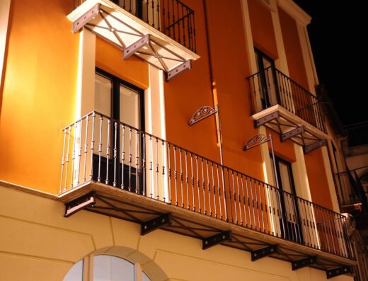 Esterno dell'Albergo Le Dodici Lune di Alessandra e Paola Coralluzzo S.N.C. con balconi in ferro battuto e insegna luminosa.