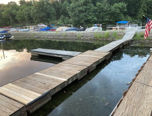 Banchina di legno con barche ormeggiate in un albergo ristorante vicino al lago.