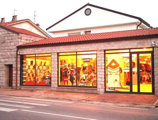 Vetrina di negozio di accessori moto: caschi, stivali, abbigliamento tecnico e moto esposte. Alternativa Moto: il tuo marketplace di fiducia per l'equipaggiamento motociclistico.